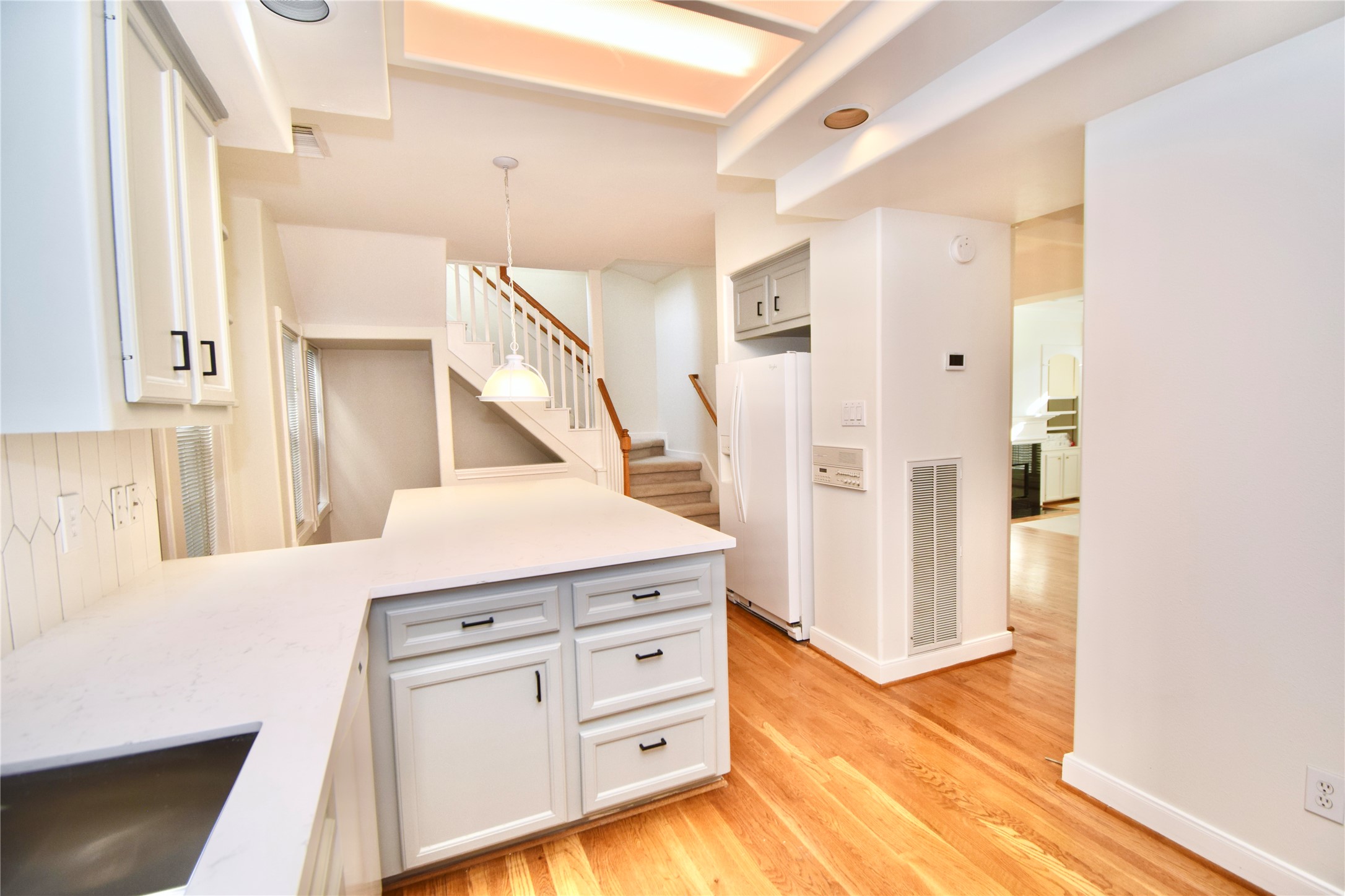 2024 Welch Street Houston, TX 77019 - Photo 6 of 18 a hallway with cabinets and wooden floor