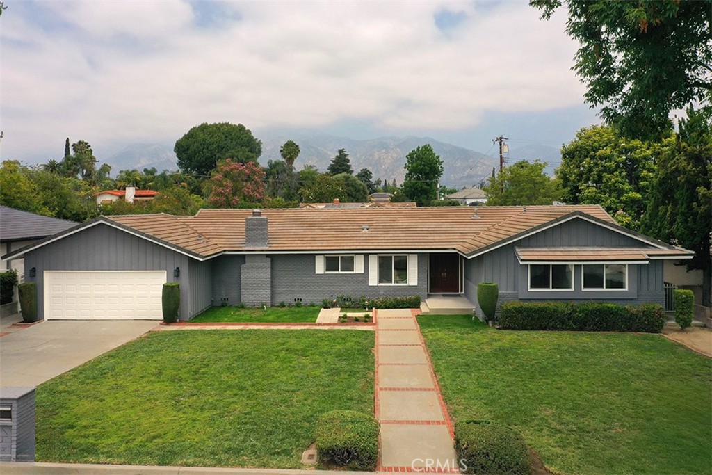a front view of a house with a yard and green space