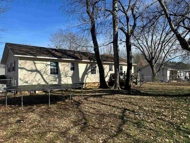 a backyard of a house with barbeque oven table and chairs