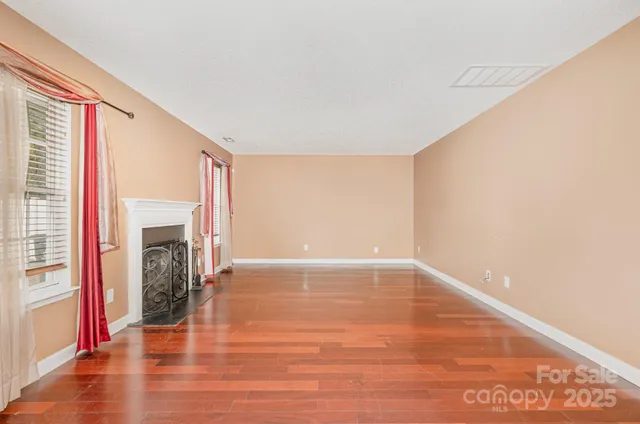 a view of a livingroom with wooden floor and a fireplace