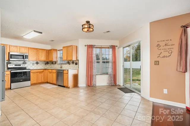a large kitchen with kitchen island granite countertop a stove a sink and a refrigerator