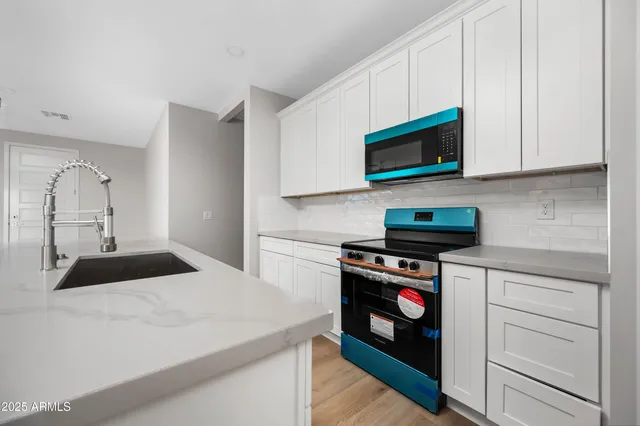 a kitchen with kitchen island white cabinets and stainless steel appliances