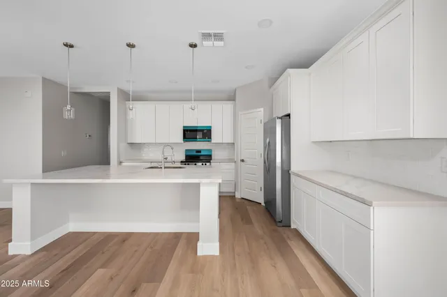 a kitchen with kitchen island a white counter top space cabinets and stainless steel appliances