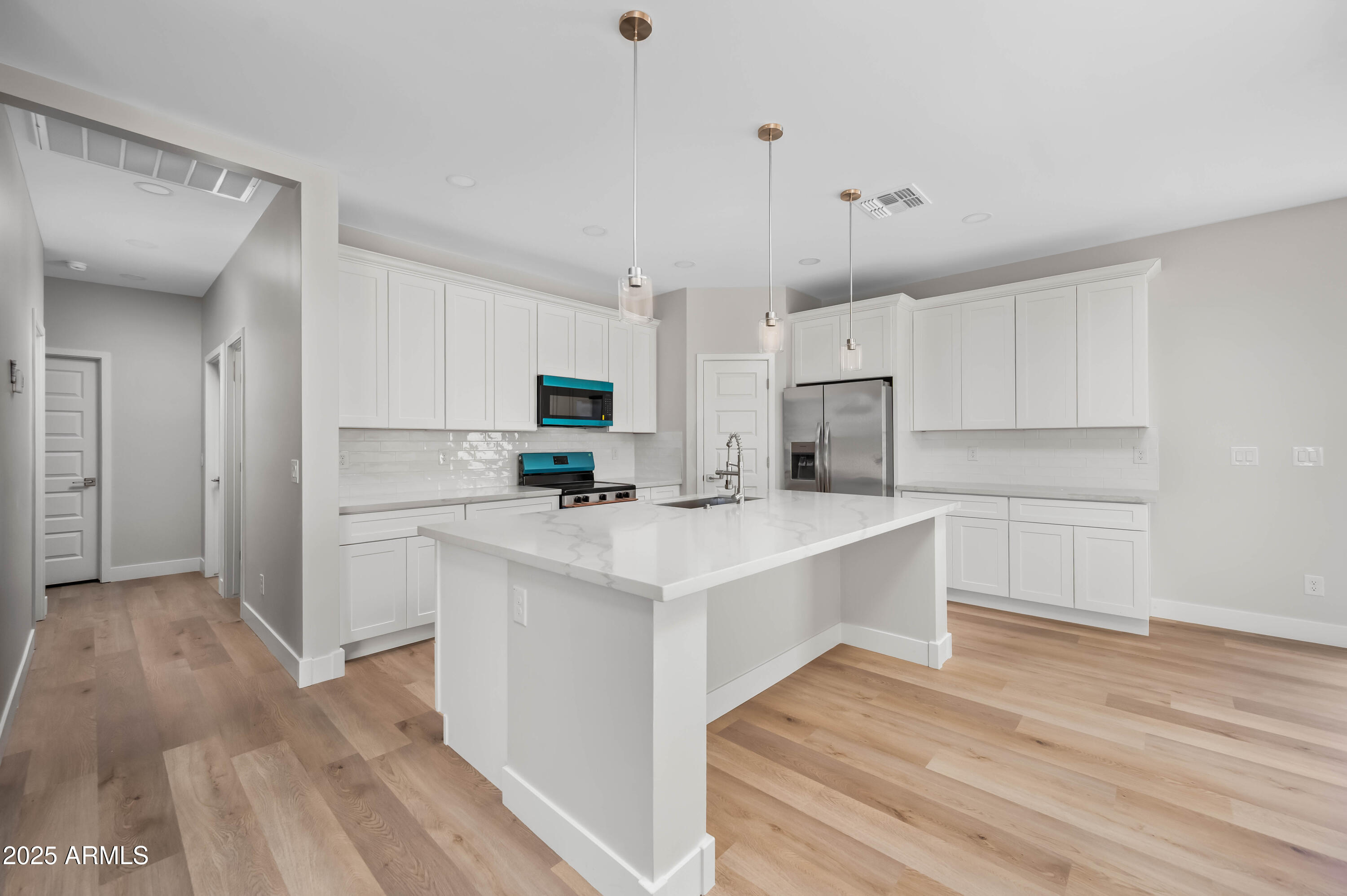 2103 Hassayampa Road Tonopah, AZ 85354 - Photo 35 of 37 a kitchen with kitchen island a white counter top space cabinets and stainless steel appliances