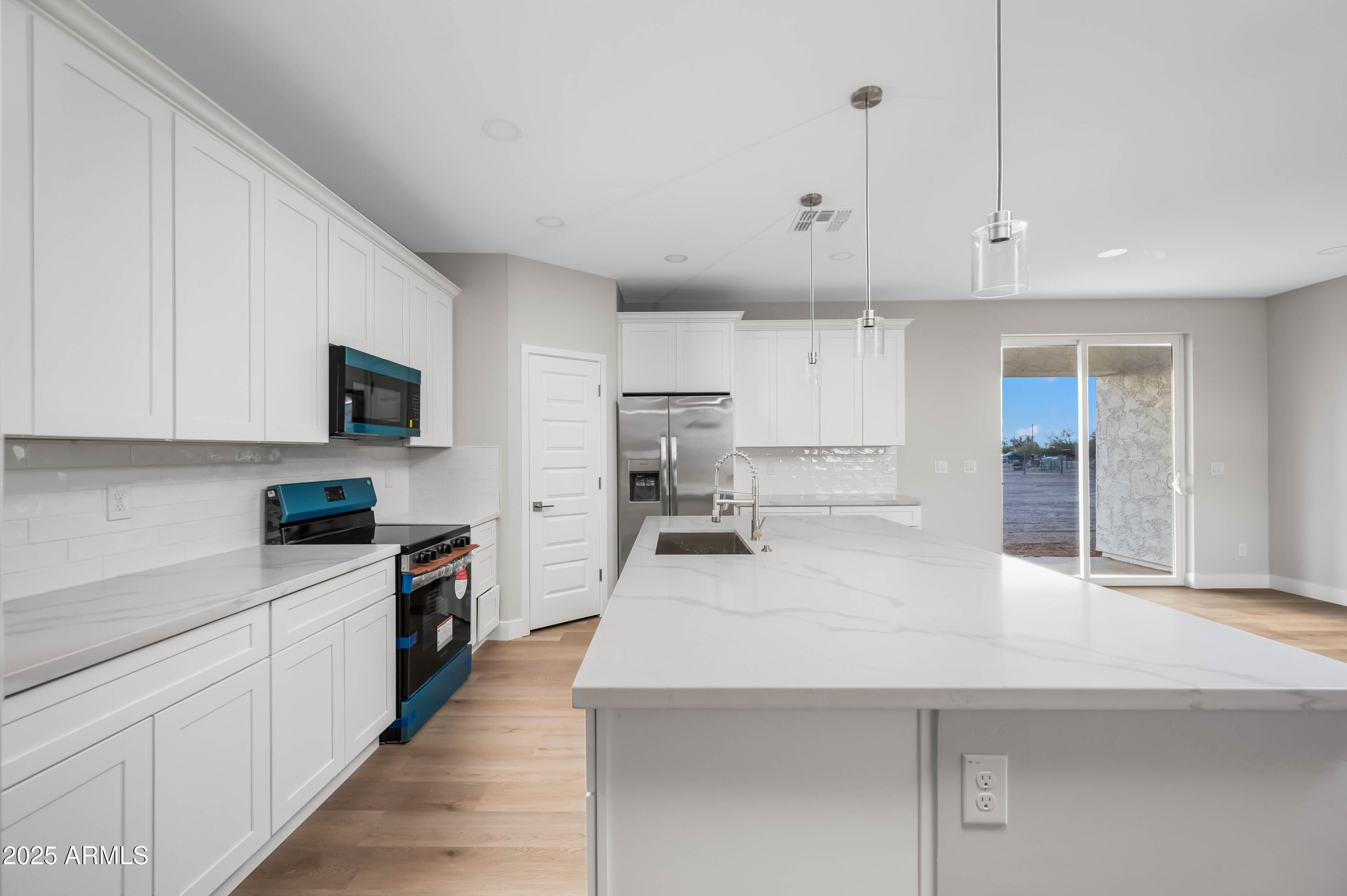 2103 Hassayampa Road Tonopah, AZ 85354 - Photo 36 of 37 a kitchen with kitchen island a sink stainless steel appliances and cabinets