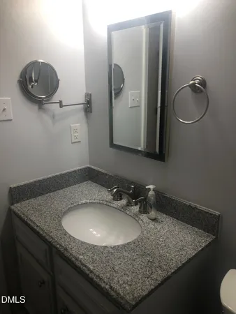 a bathroom with a granite countertop sink and a mirror