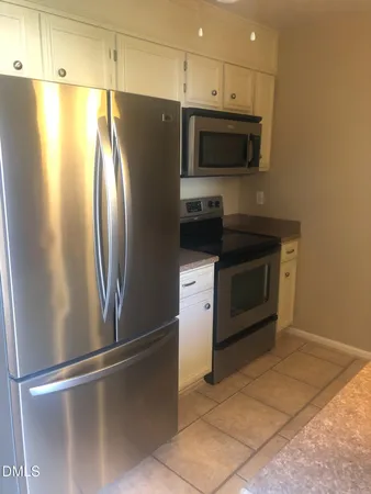 a metallic refrigerator freezer sitting in a kitchen