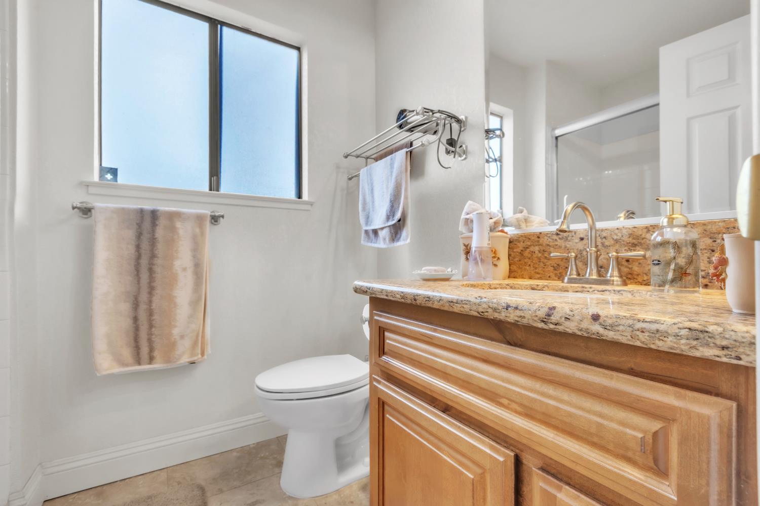 10973 Hirschfeld Way Rancho Cordova, CA 95670 - Photo 17 of 41 a bathroom with a granite countertop sink a toilet and a mirror