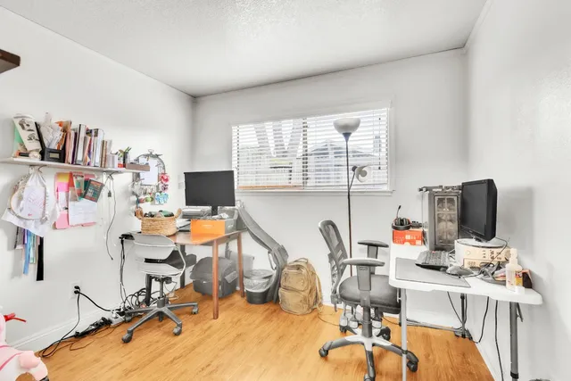 a view of a workspace with furniture and a window
