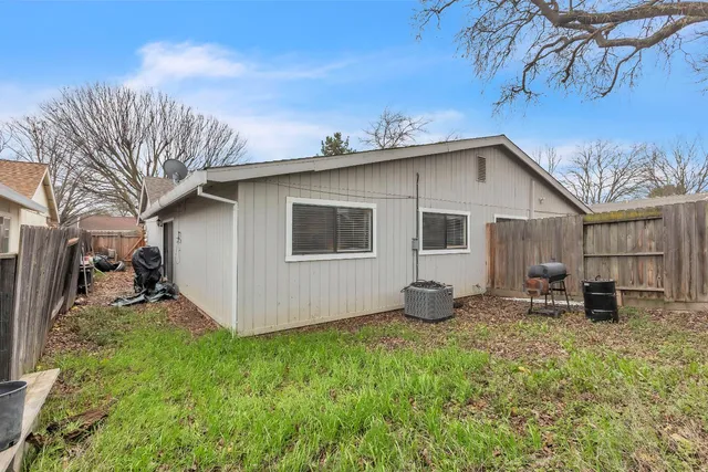 a view of a backyard with wooden fence and a bench