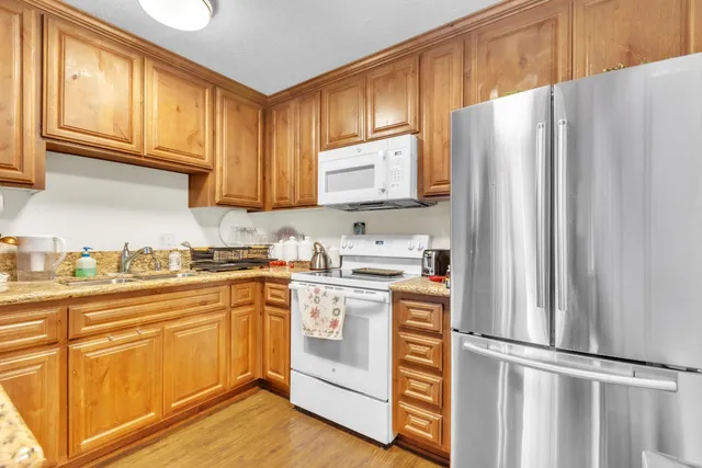 a kitchen with stainless steel appliances granite countertop a refrigerator sink and cabinets