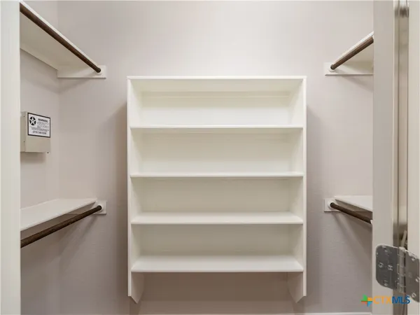 a view of walk in closet with empty racks