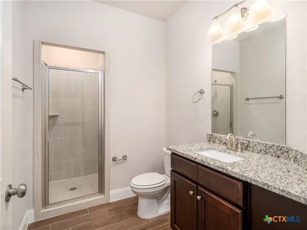 a bathroom with a granite countertop sink toilet and shower