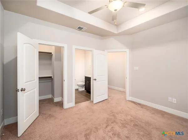 an empty room with a ceiling fan and closet