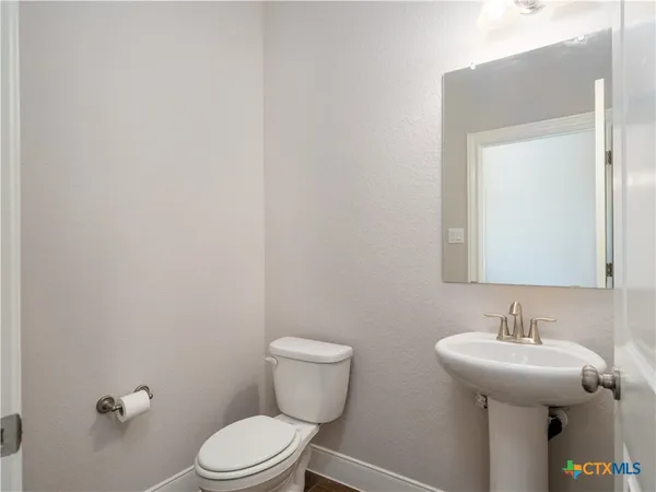 a bathroom with a toilet a sink and mirror
