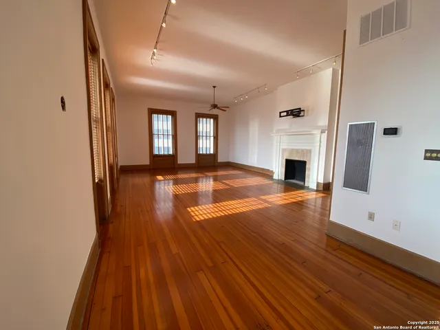 a view of empty room with wooden floor