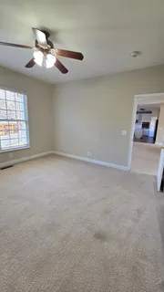 a view of an empty room with a chandelier fan