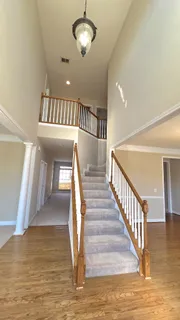 a view of staircase and hall with wooden floor