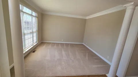 a view of empty room with wooden floor and window