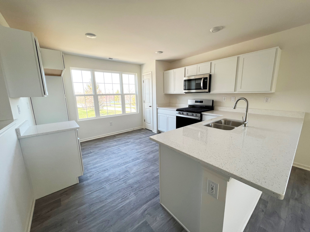 2241 Sassafras Way, Unit F Wonder Lake, IL 60097 - Photo 3 of 46 a kitchen with microwave a stove and cabinets