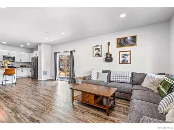 a living room with furniture and kitchen view