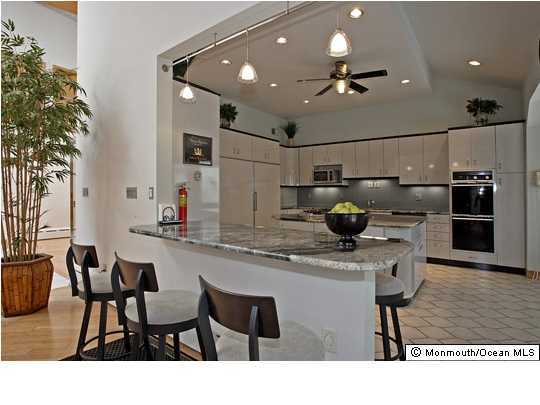116 Beacon Hill Road Morganville, NJ 07751 - Photo 2 of 3 a kitchen with stainless steel appliances kitchen island granite countertop a sink and cabinets