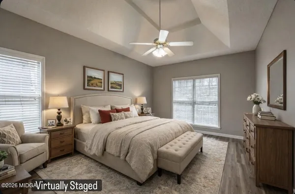 a bedroom with a large bed couch and windows
