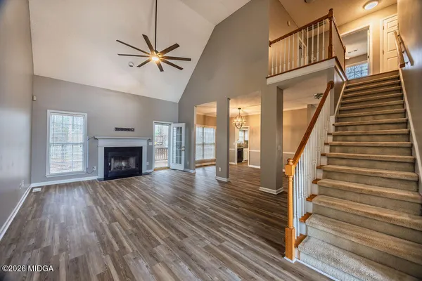 a view of a livingroom with wooden floor fireplace and a window