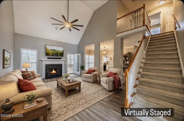 a living room with furniture a fireplace and a ceiling fan