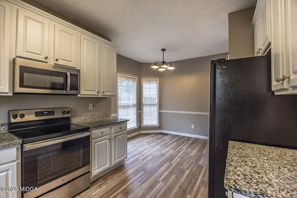 a kitchen with stainless steel appliances granite countertop a stove a microwave and a refrigerator