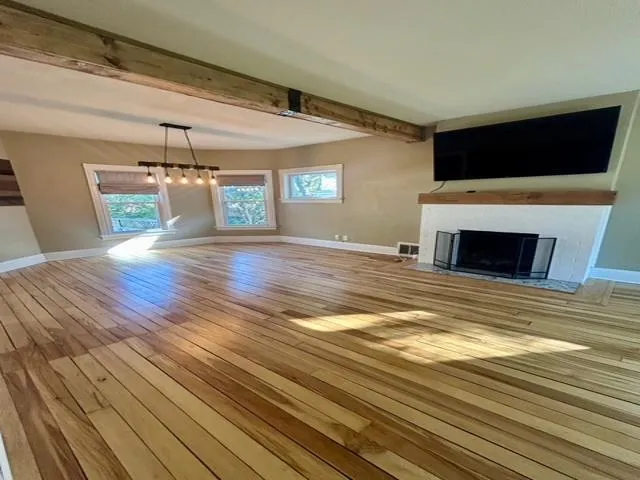 a view of a livingroom with wooden floor and fireplace