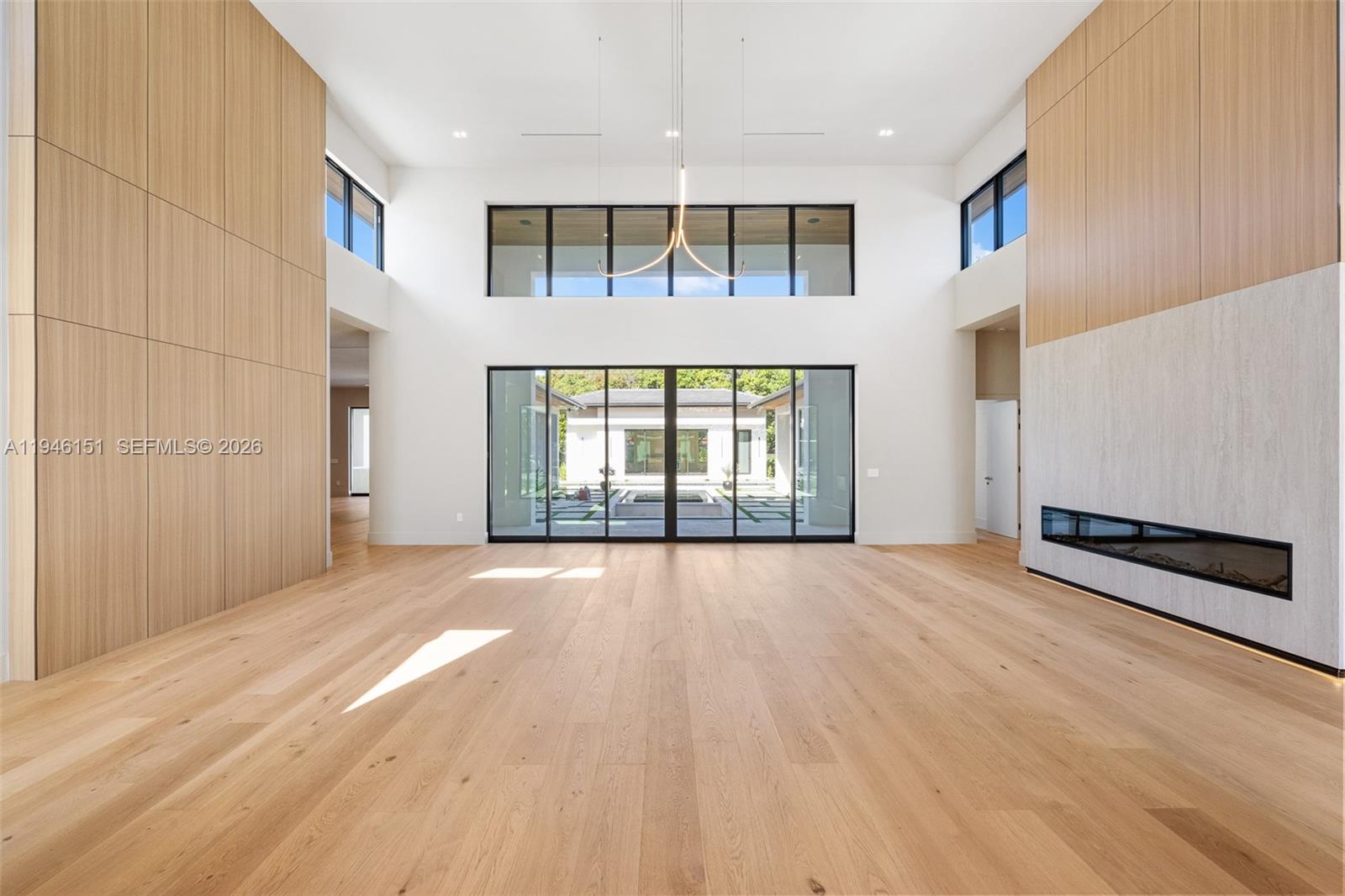 7725 Southwest 114th Street Pinecrest, FL 33156 - Photo 11 of 94 a view of an empty room with a window and wooden floor