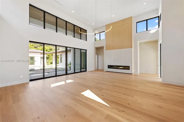 a kitchen with stainless steel appliances kitchen island a chandelier and a wooden floor