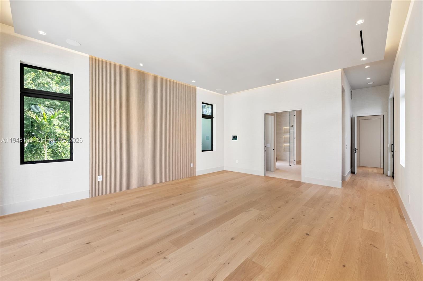 7725 Southwest 114th Street Pinecrest, FL 33156 - Photo 51 of 94 a view of an empty room with wooden floor and a window