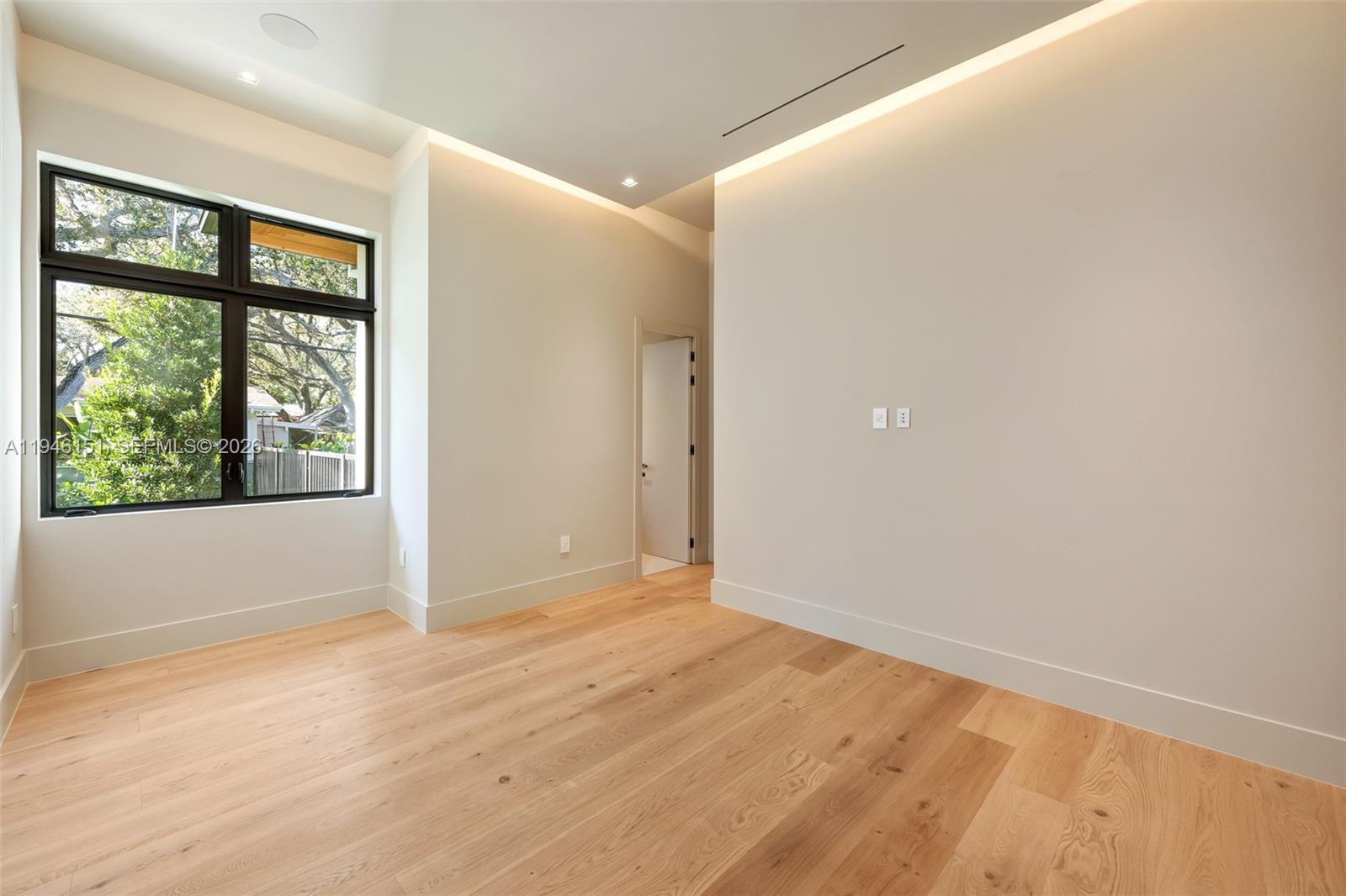 7725 Southwest 114th Street Pinecrest, FL 33156 - Photo 61 of 94 a view of an empty room with wooden floor and windows