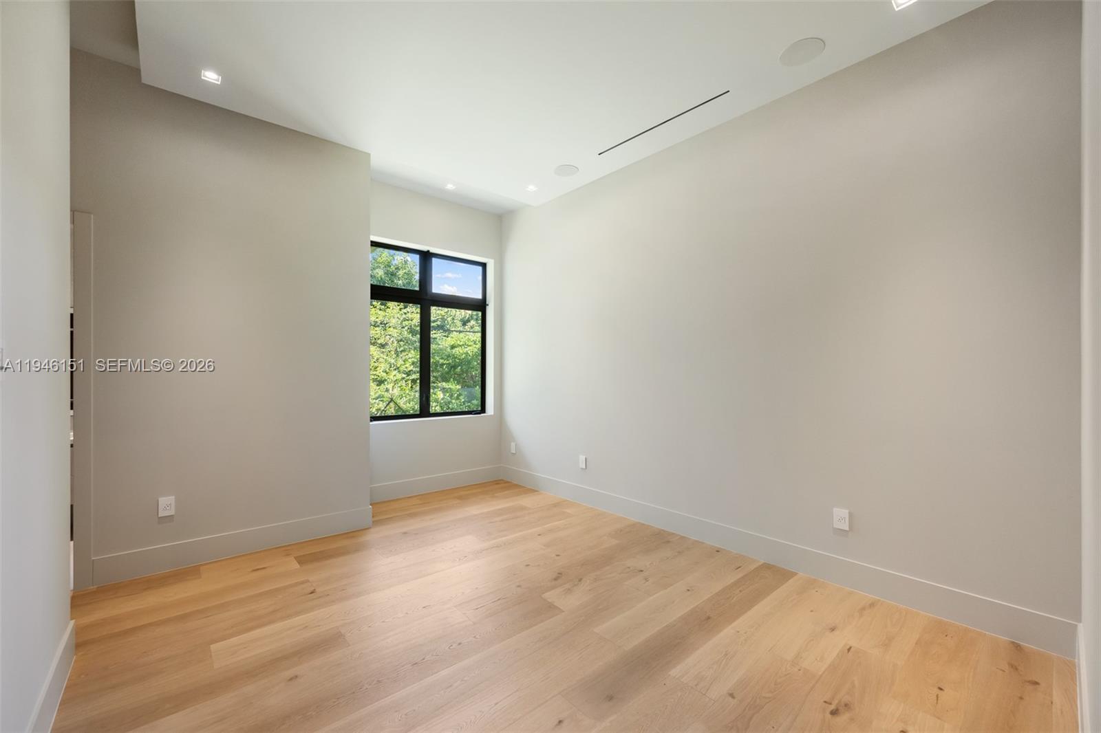7725 Southwest 114th Street Pinecrest, FL 33156 - Photo 70 of 94 an empty room with wooden floor and windows