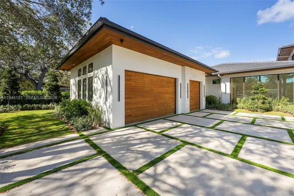 a view of a kitchen with kitchen island a large counter top and stainless steel appliances