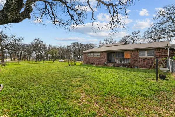 a view of a house with backyard and a tree