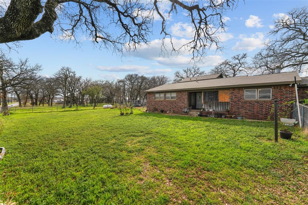 a view of a house with backyard and a tree