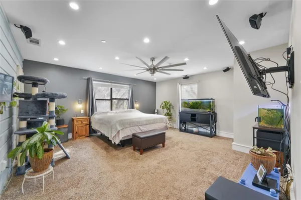 a spacious bedroom with a bed a couch and dresser