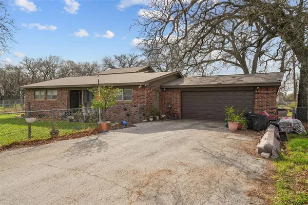 a view of a yard with a tree in front of house