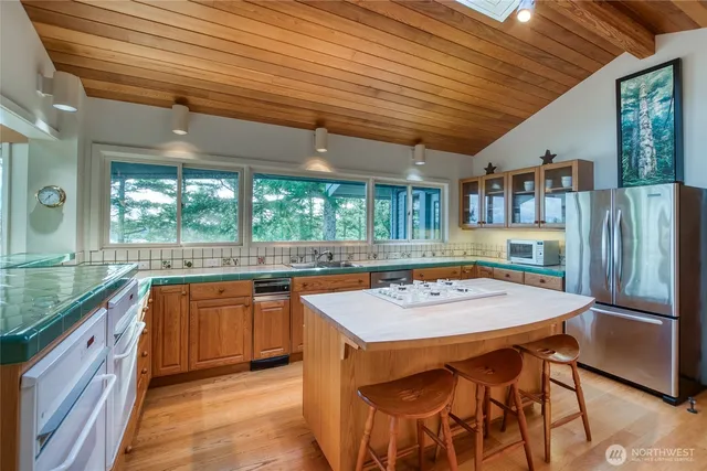 a kitchen with stainless steel appliances granite countertop table chairs sink and cabinets