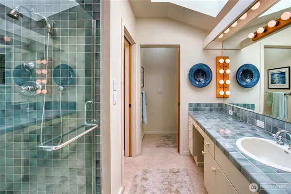 a bathroom with a sink a mirror and shower