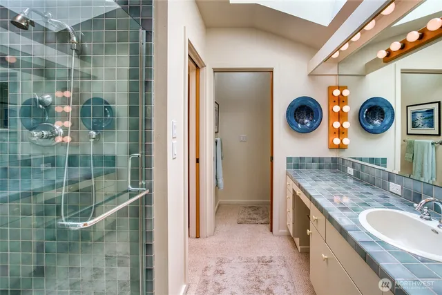 a bathroom with a sink a mirror and shower