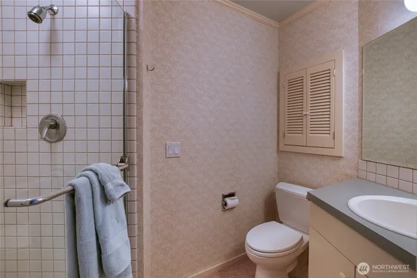 a bathroom with a granite countertop toilet and sink