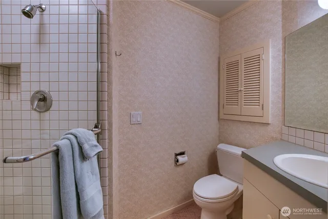 a bathroom with a granite countertop toilet and sink