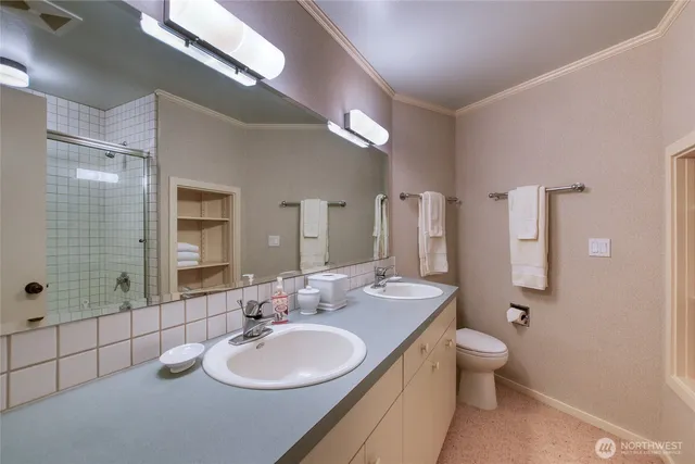 a bathroom with a double vanity sink toilet mirror and shower
