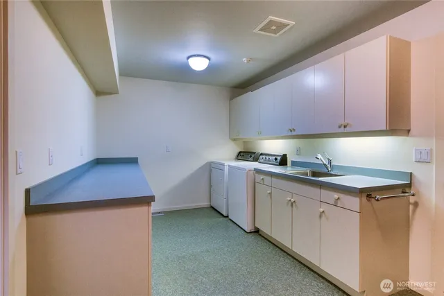 a kitchen with cabinets appliances a sink and a counter top space