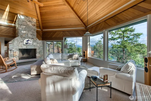 a living room with furniture a fireplace and a large window