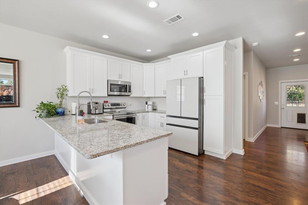 7232 Courtney Drive Azle, TX 76020 - Photo 11 of 39 a kitchen with stainless steel appliances granite countertop a refrigerator a stove a sink cabinets and a wooden floor